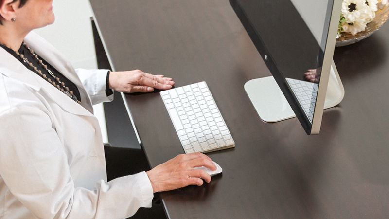 Women sitting on a office chair while using a Computer