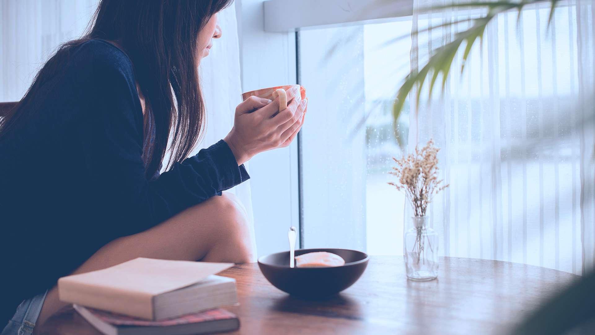 lady Looking Out Window holding Coffee