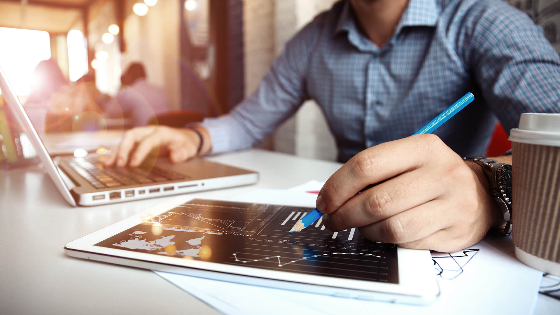 Man on a laptop and tablet viewing a statistic