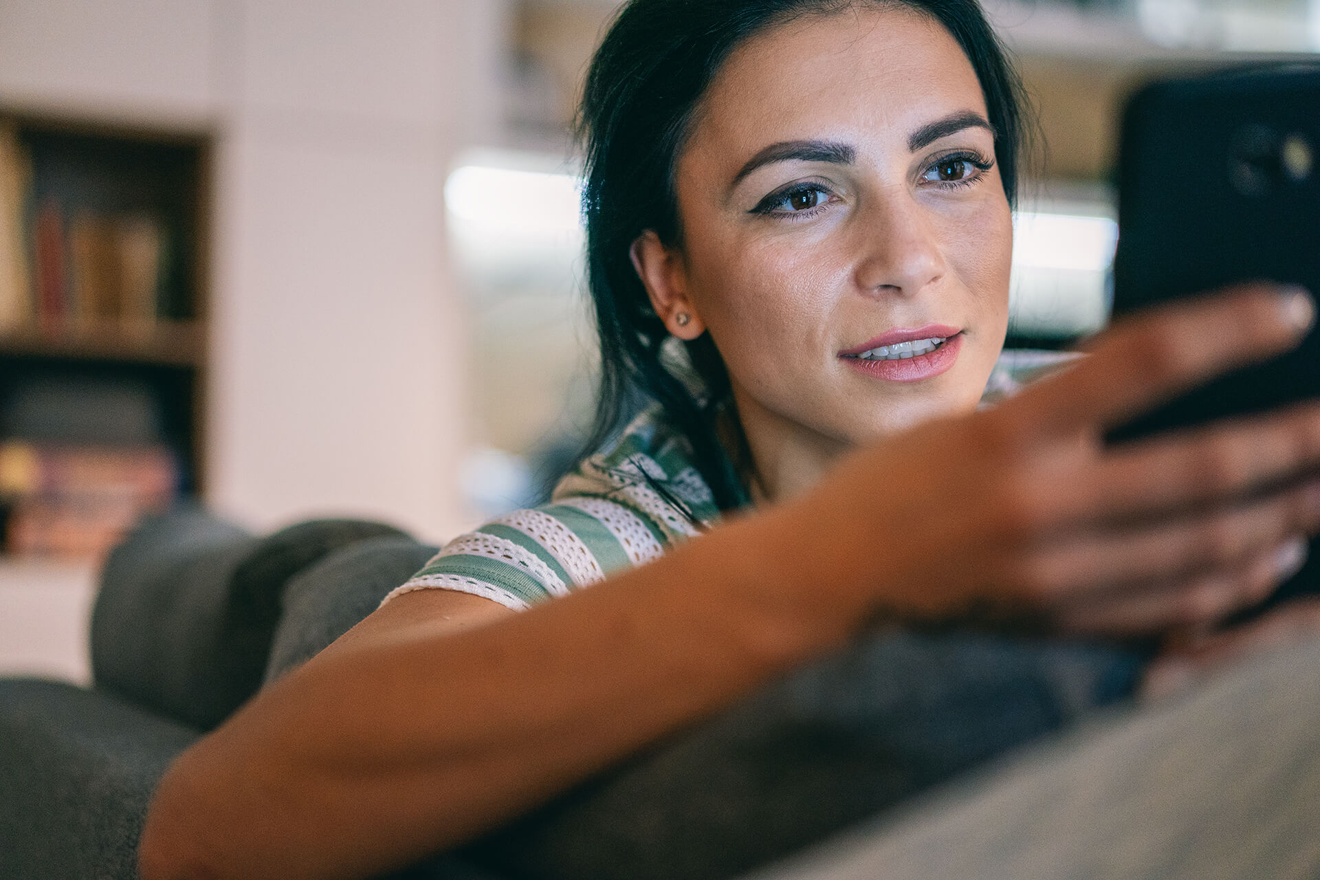 Lady on couch with a smartphone